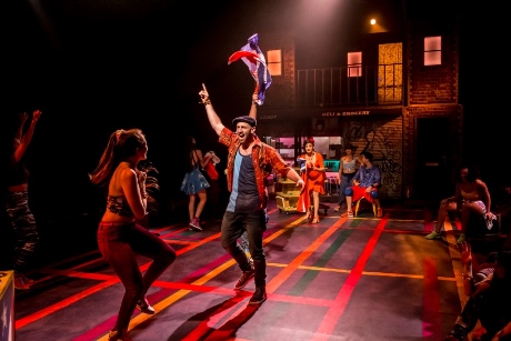 Sam Mackay as Usnavi and the cast of In The Heights